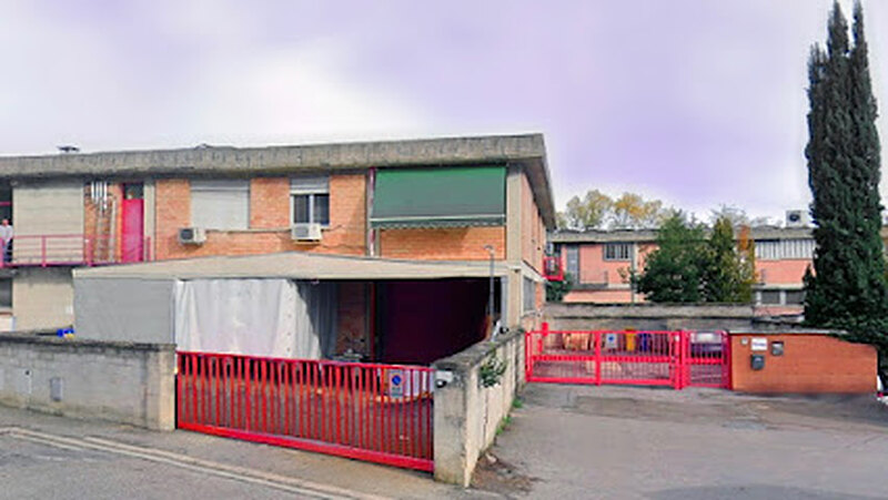 Ingresso della sede di OmnitekStore in Via A. Meucci 5 a Bagno a Ripoli: edificio in mattoni con tenda verde, i due cancelli rossi e il piazzale